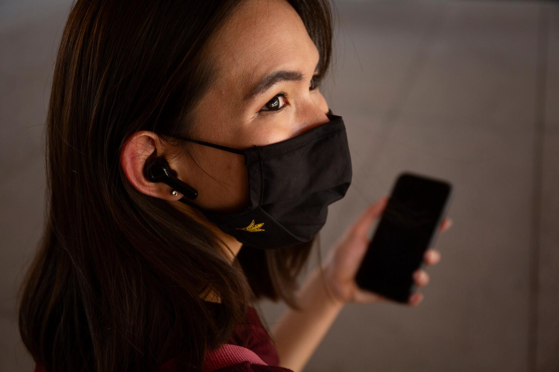 Person on their phone while wearing a face mask