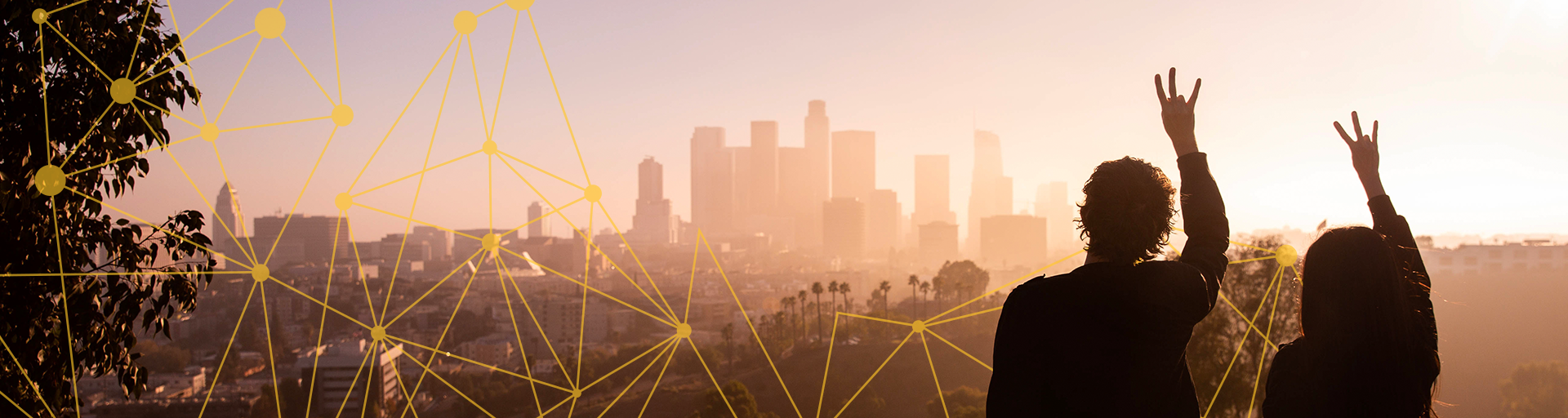 Two people staring at a city skyline holding the Forks Up hand sign
