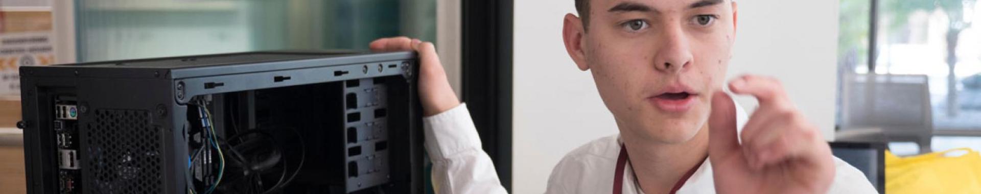 Person next to a computer with the side panel off