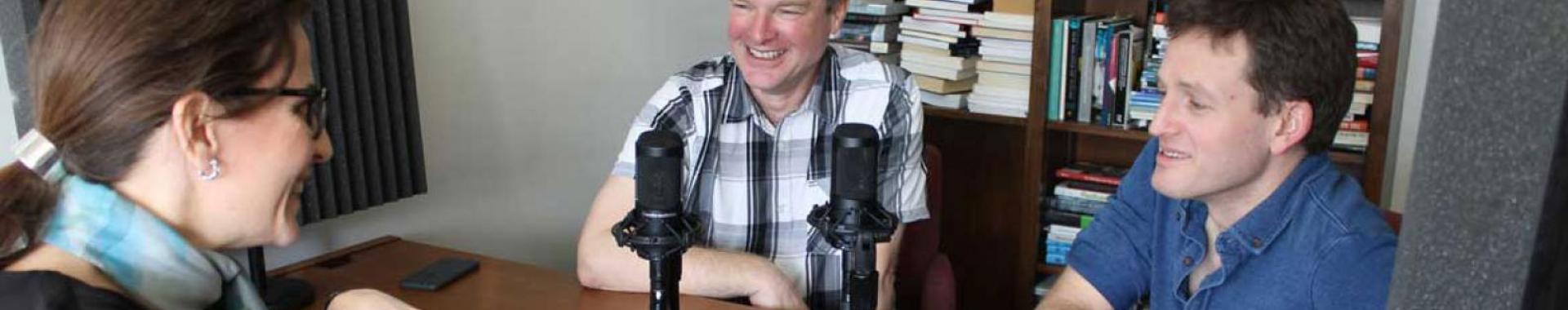 Three people talking into microphones